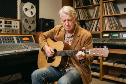 Chanteur britannique méconnu des années 70 dans un studio d'enregistrement vintage avec guitare acoustique et équipements analogiques