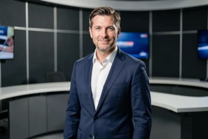 Présentateur homme en costume bleu marine dans un studio de télévision news moderne